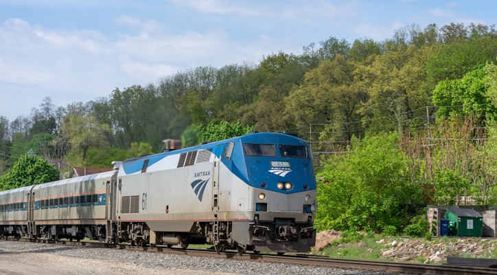 a blue and white train traveling down train tracks