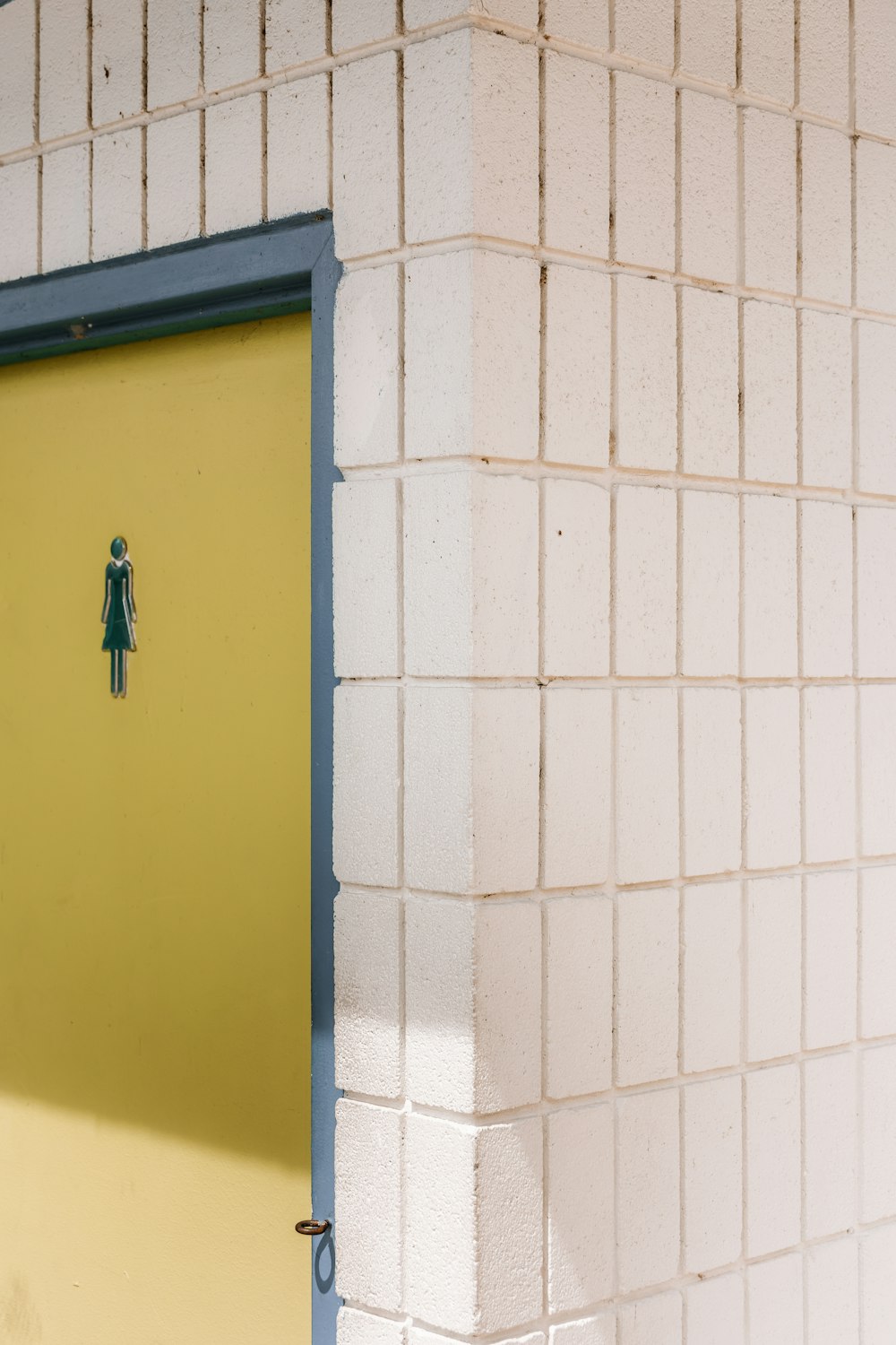 女性のステッカーが貼られた黄色いドア