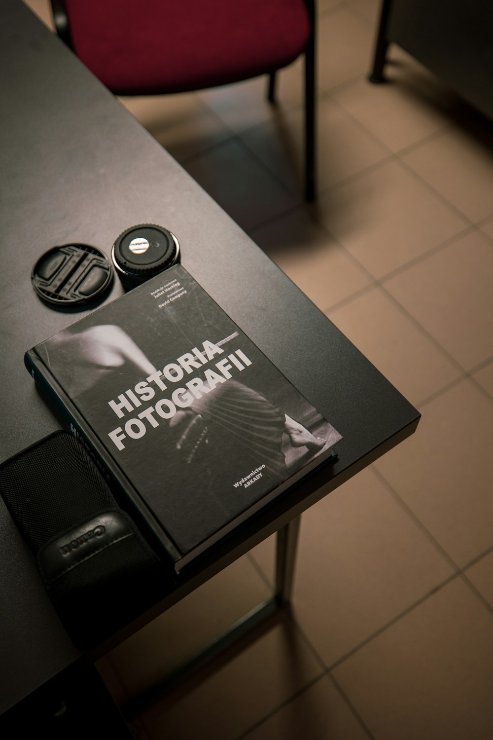 a book sitting on top of a table next to a red chair