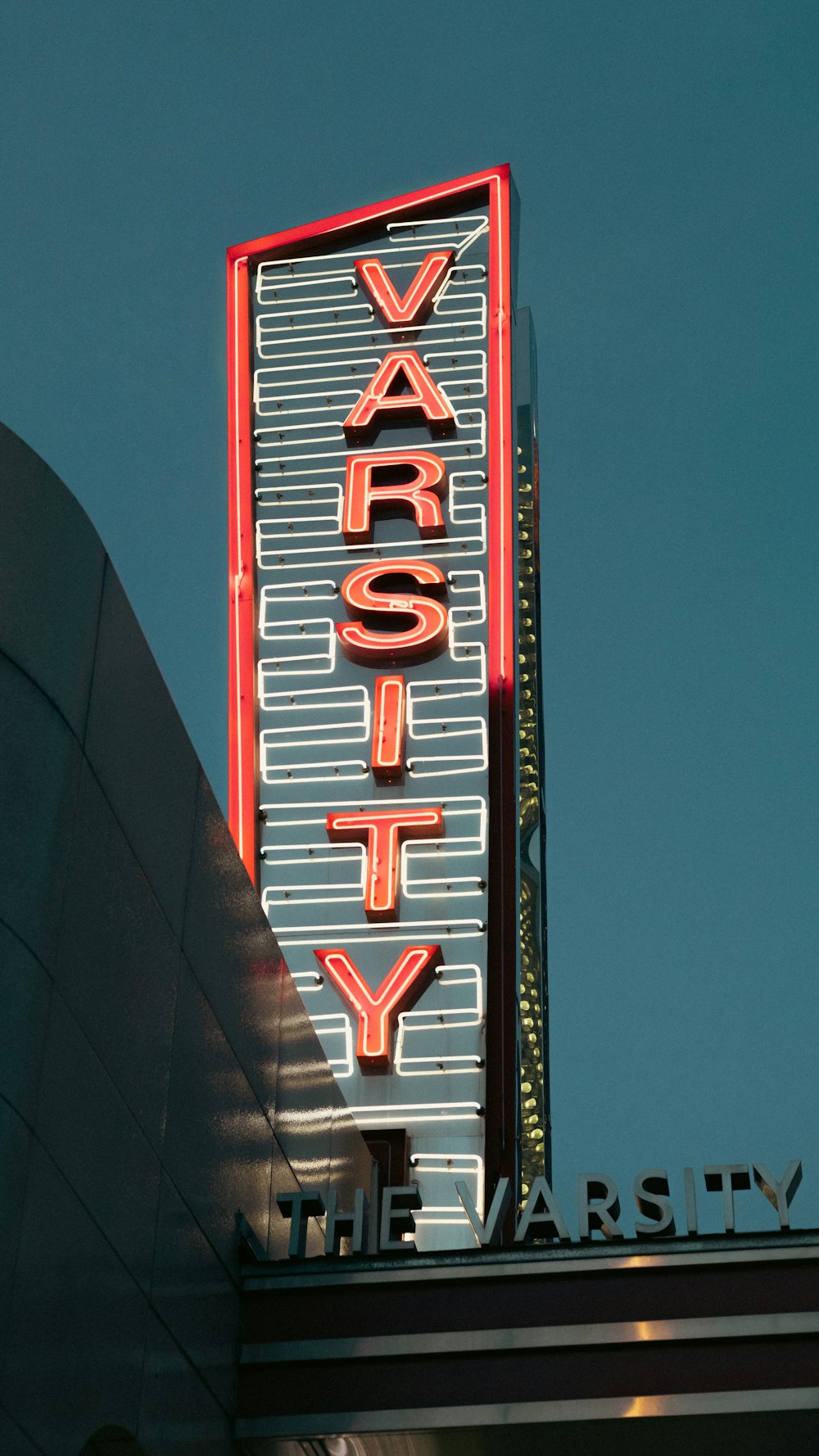 a very tall neon sign on the side of a building