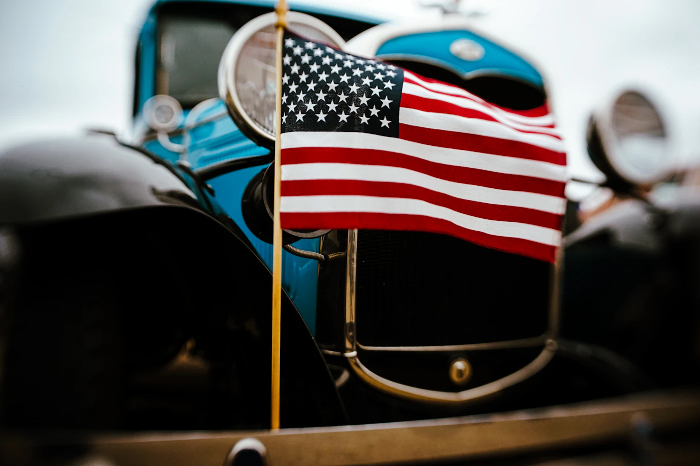 A small American flag on the front of a classic car, a symbol of the start of summer and a Memorial Day weekend road trip in New Hampshire