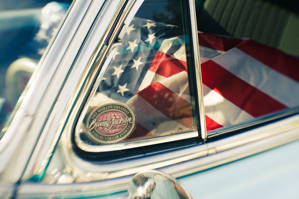 a reflection of an american flag in a car's side mirror