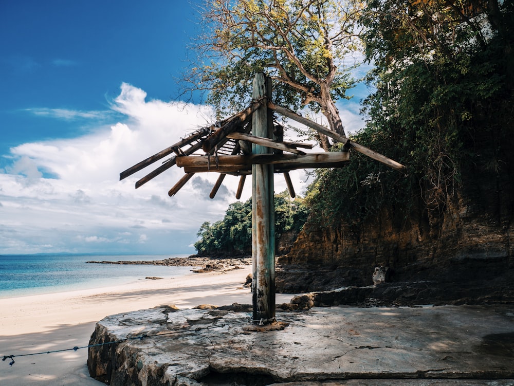 a wooden structure sitting on top of a sandy beach
