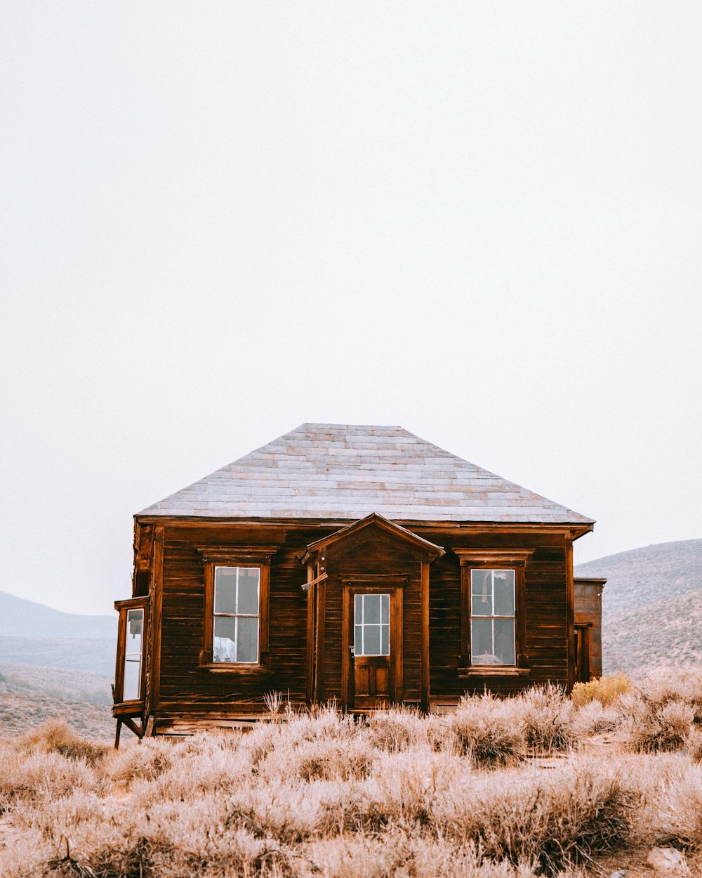 a small wooden house sitting in the middle of a field