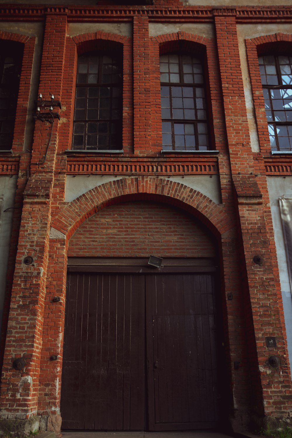 a large brick building with two brown doors
