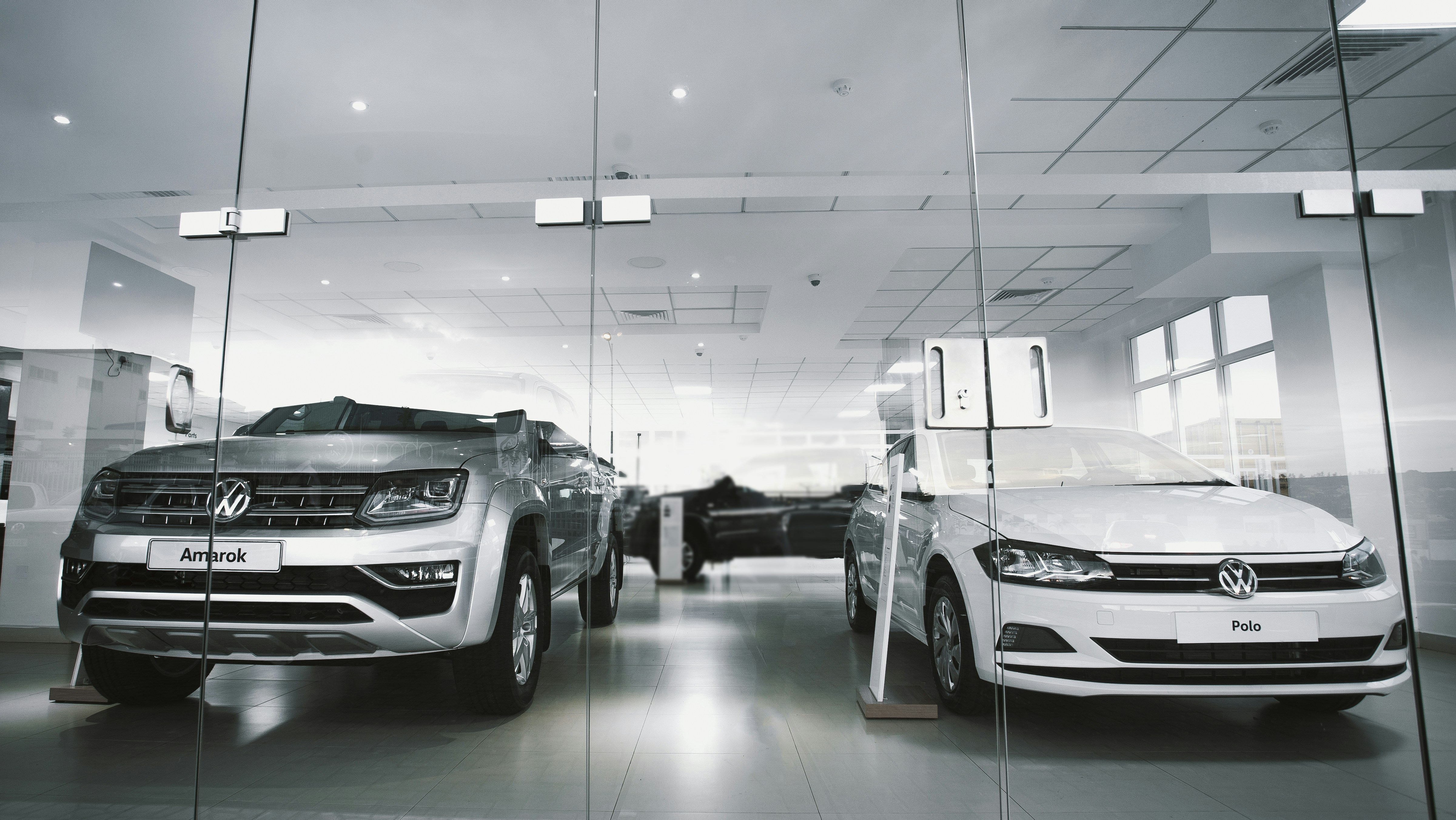 a couple of cars are parked in a showroom
