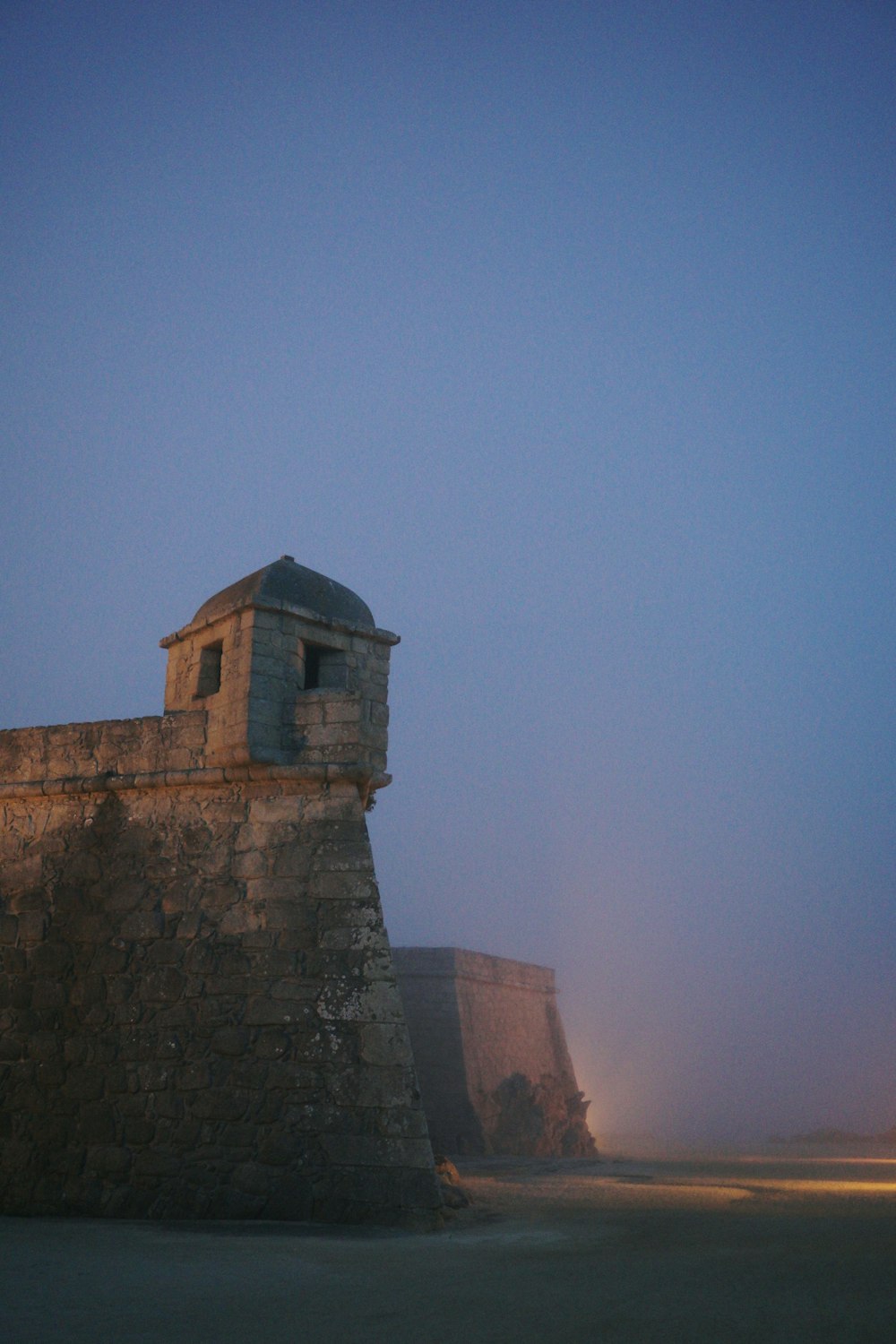 a stone wall with a clock tower on top of it