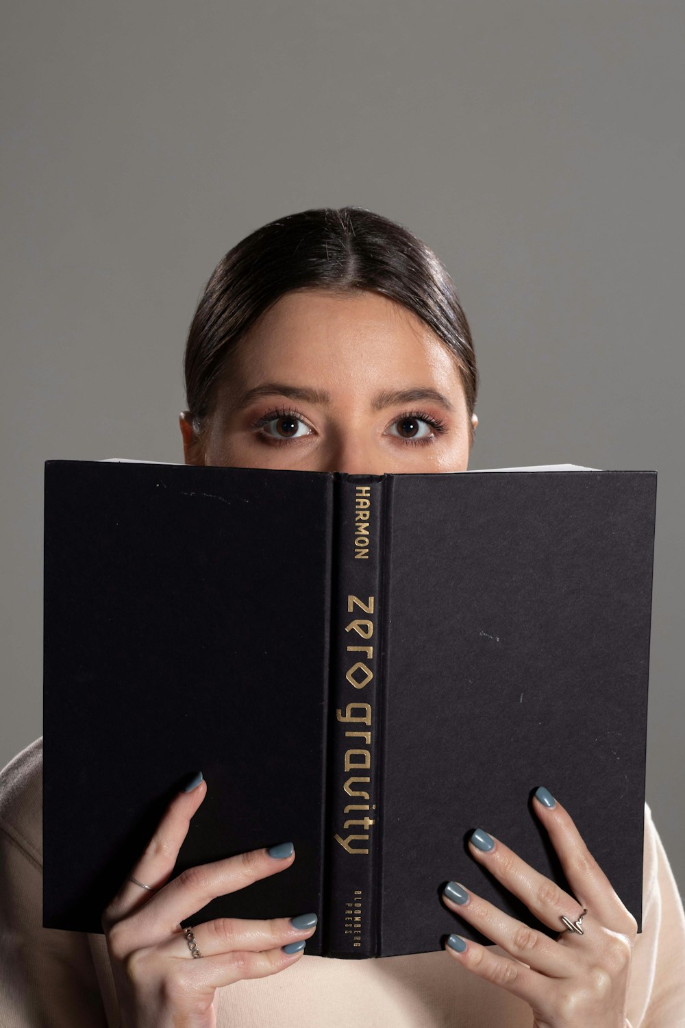 a woman holding a book over her face