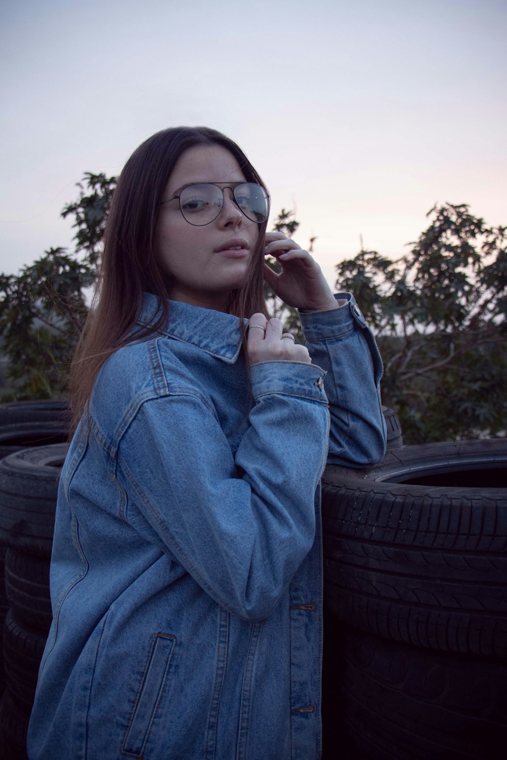 a woman in a denim jacket talking on a cell phone