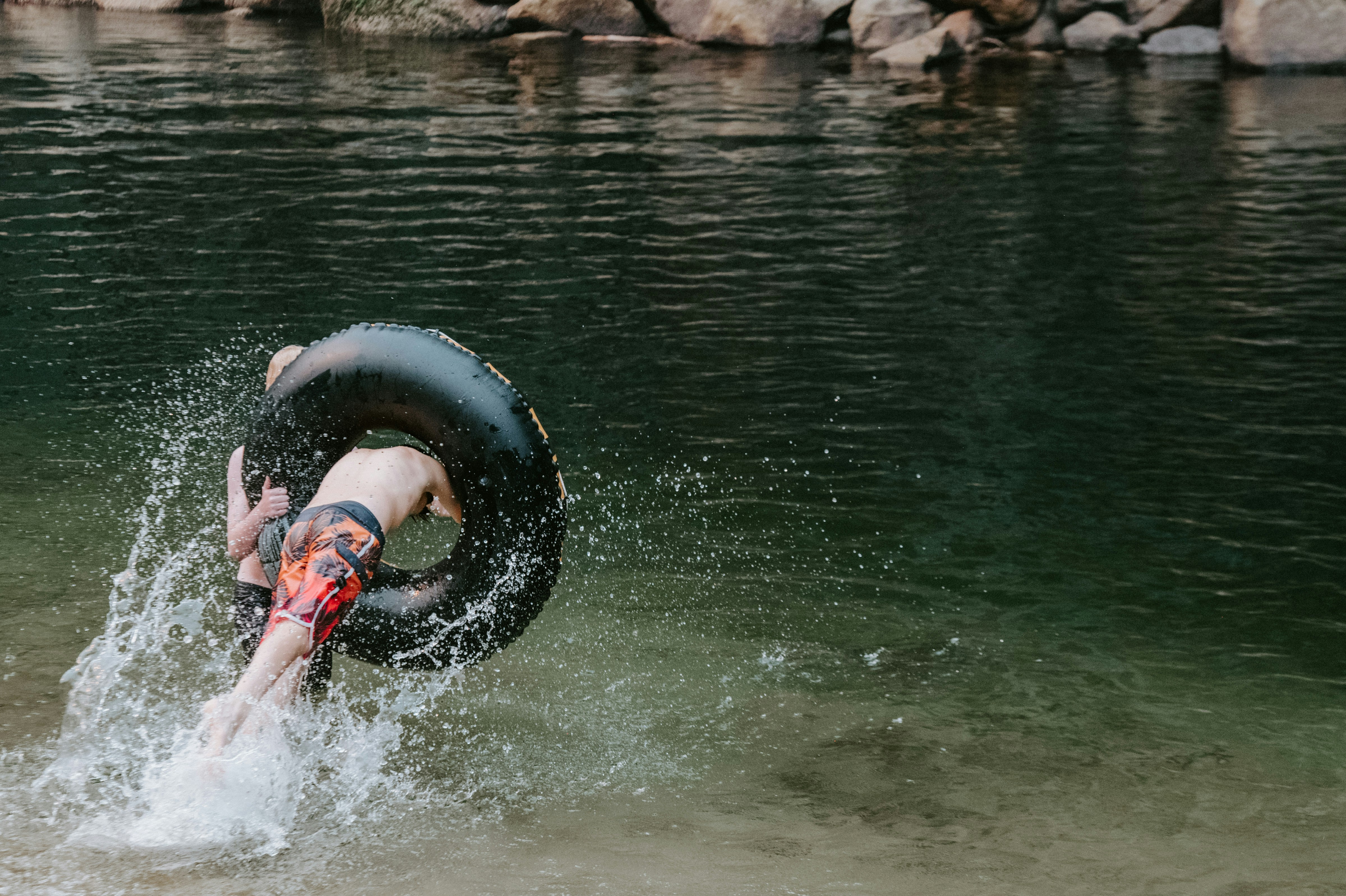 Person, die mit einem Schlauch ins Wasser spritzt
