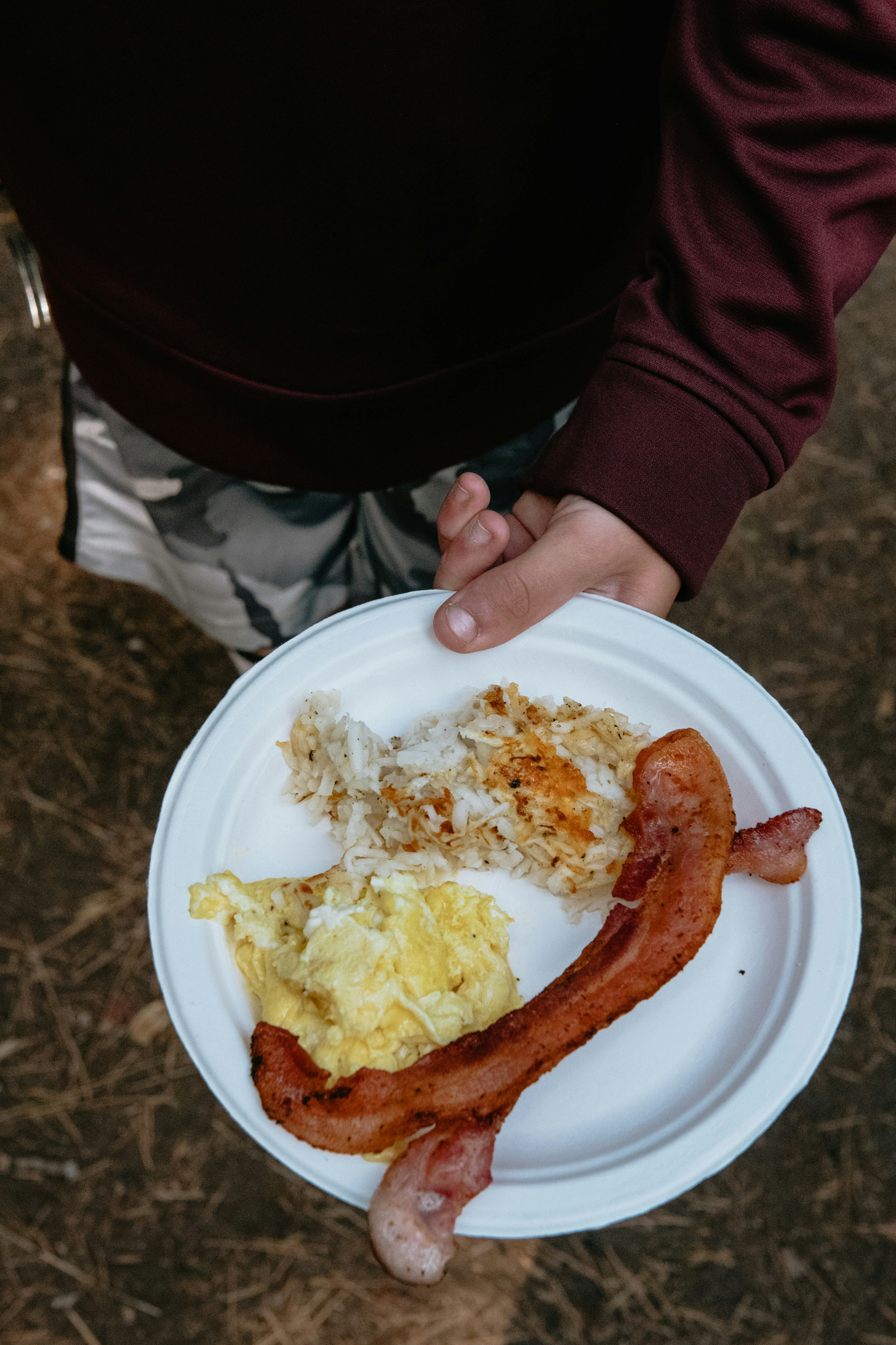 Plate of scrambled eggs, hash browns, and bacon