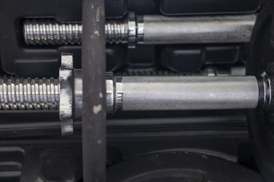 Close-up of textured grip handles on a pair of dumbbells.