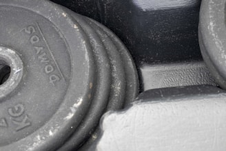 A close-up of a collection of different-sized rusty weight plates stacked together.