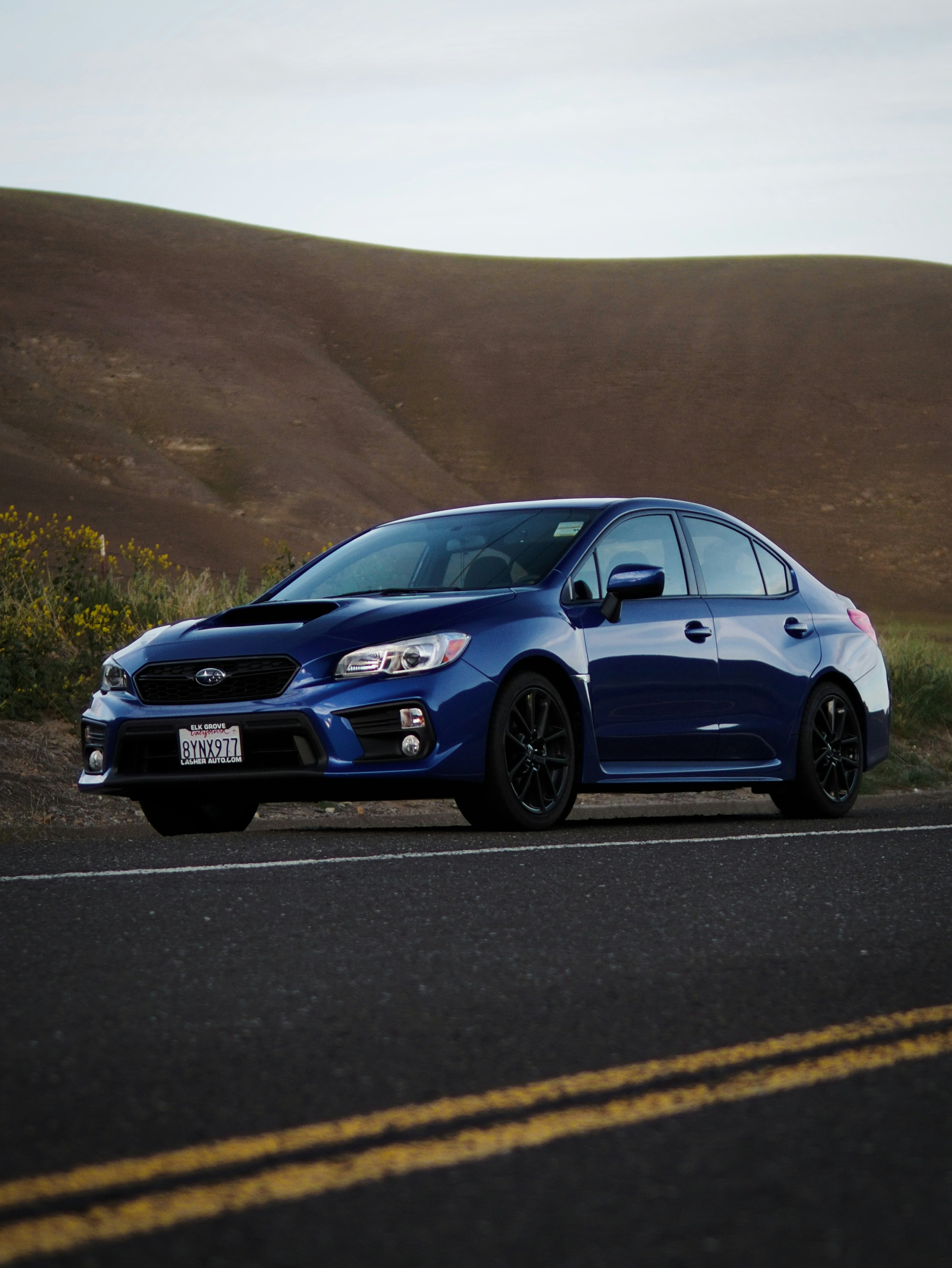 a blue car parked on the side of the road