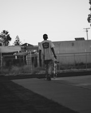 Close-up of hands holding a skateboard on a city sidewalk.