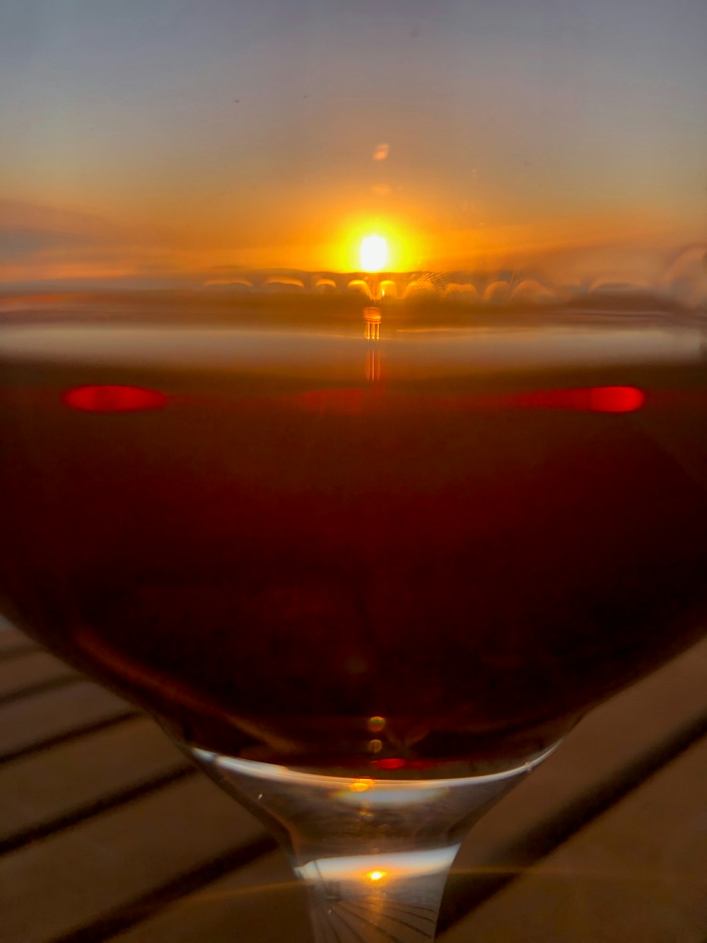 a glass of wine sitting on top of a wooden table