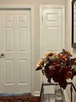 Housekeeper arranging fresh flowers in a hotel hallway.
