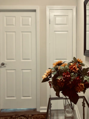 Housekeeper arranging fresh flowers in a hotel hallway.