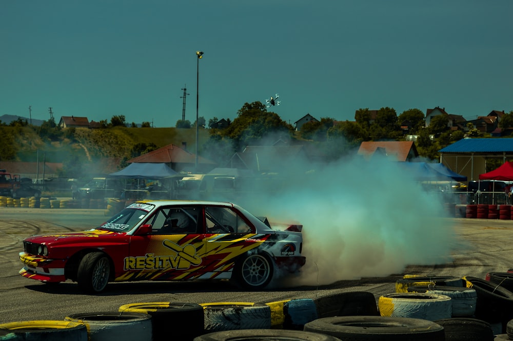 a car with smoke coming out of it driving on a track