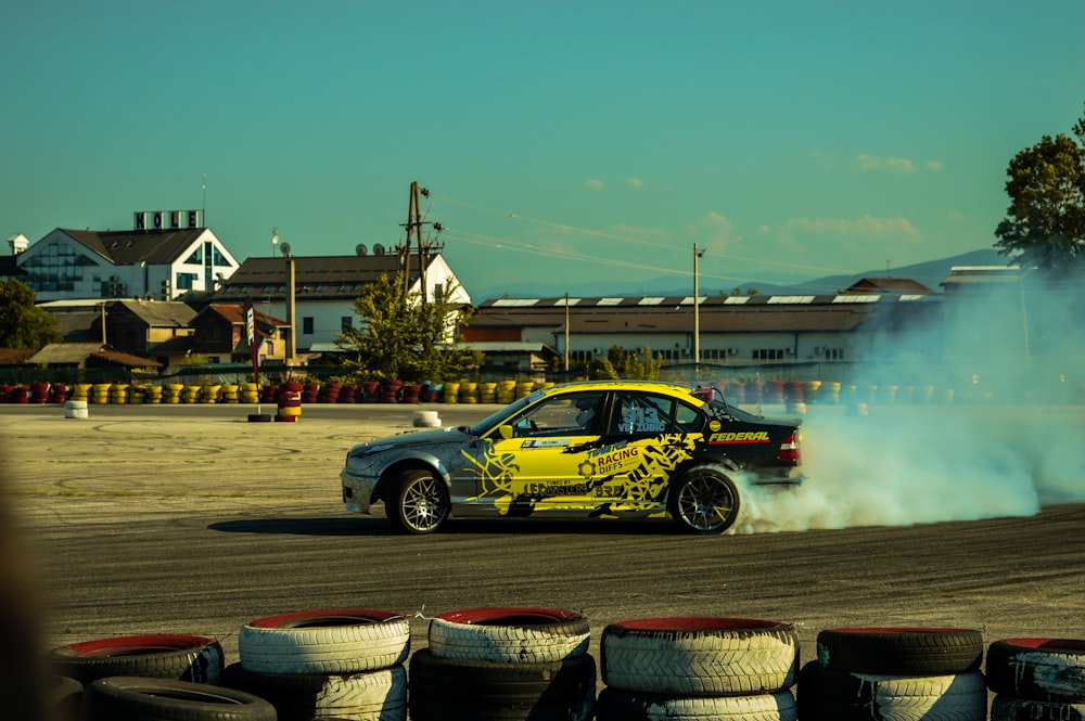 a yellow car driving on a track with smoke coming out of it