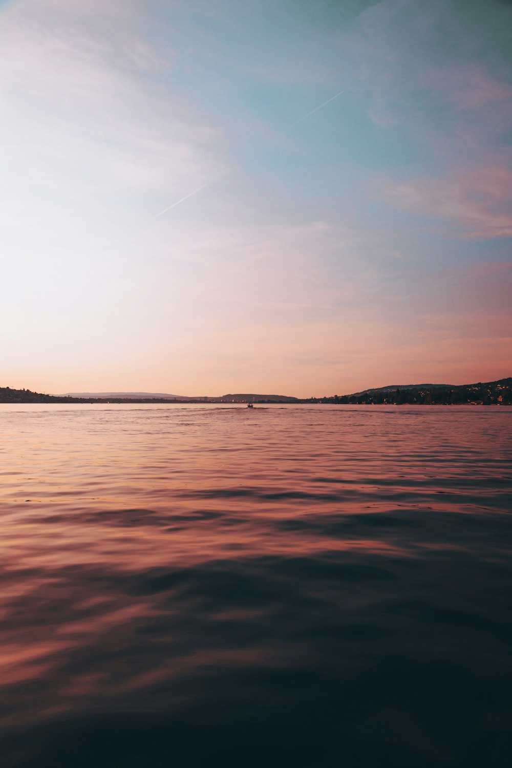 a body of water with a sky in the background