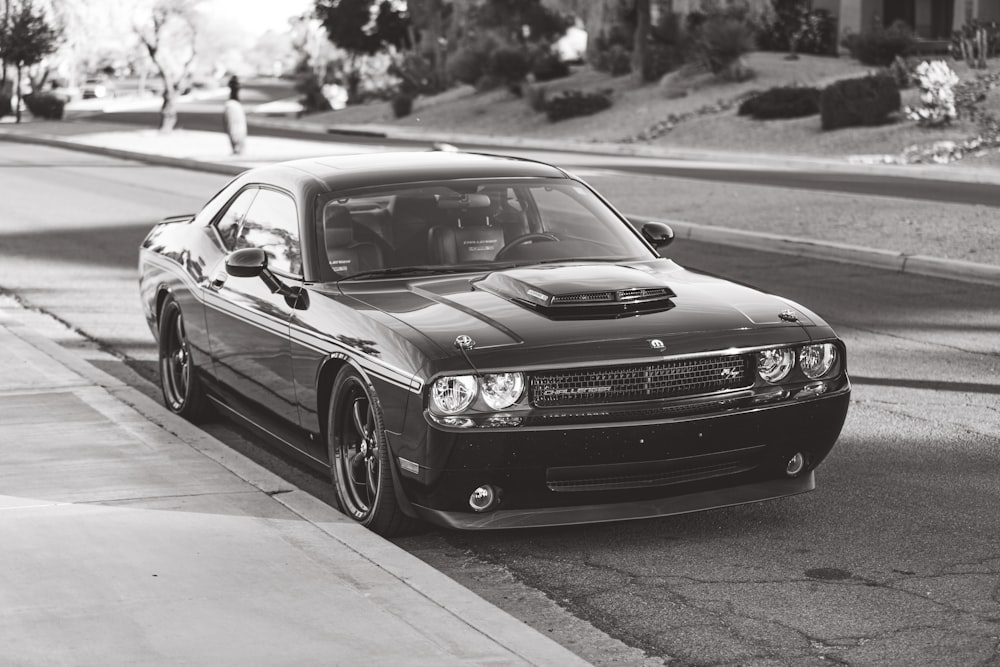 a black and white photo of a car parked on the side of the road