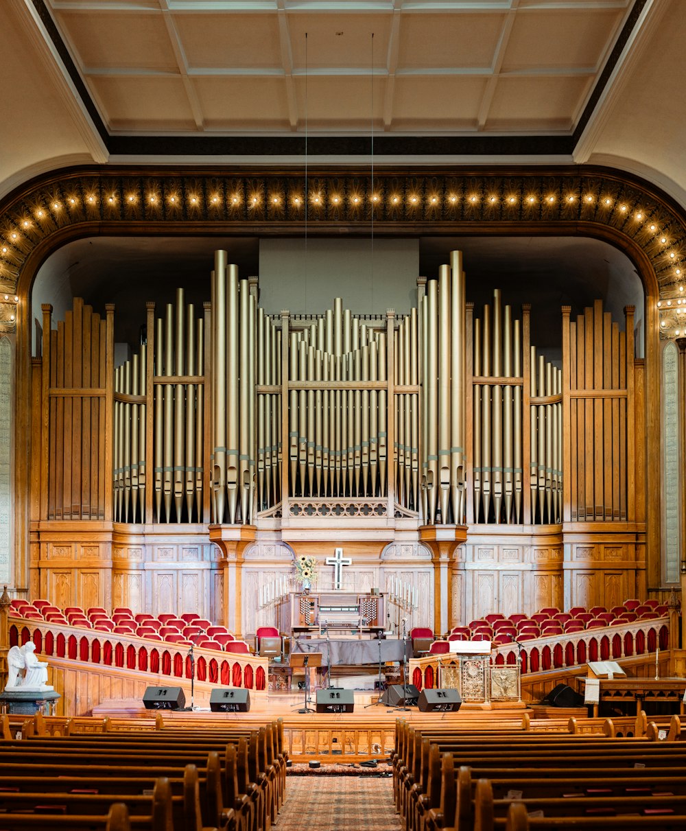 a large pipe organ in a church with red seats