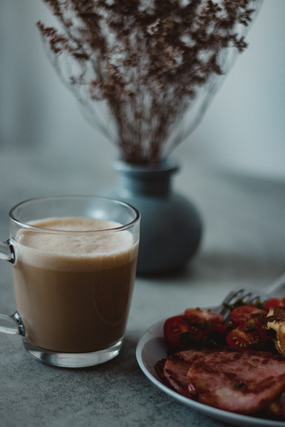 a cup of coffee next to a plate of food