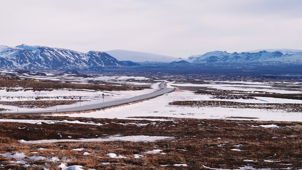 Une route sinueuse au milieu d’un champ enneigé