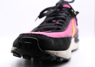 a pair of black and pink sneakers on a white surface