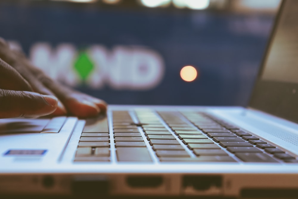 a close up of a person typing on a laptop