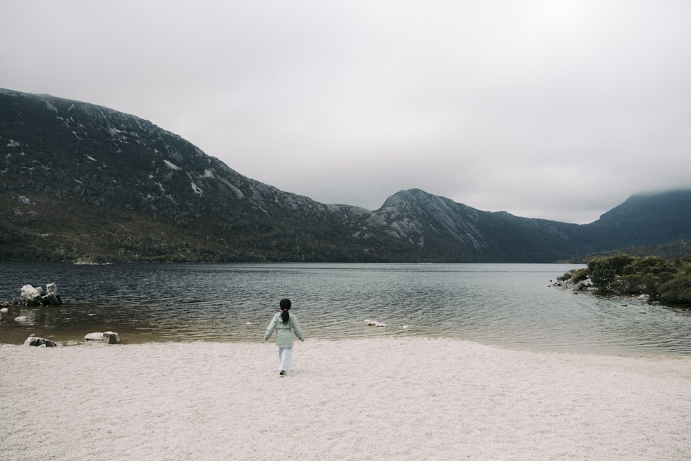 a person standing on a beach near a body of water