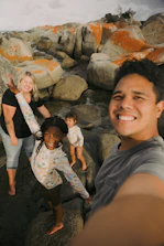 a group of people standing on top of a rocky beach