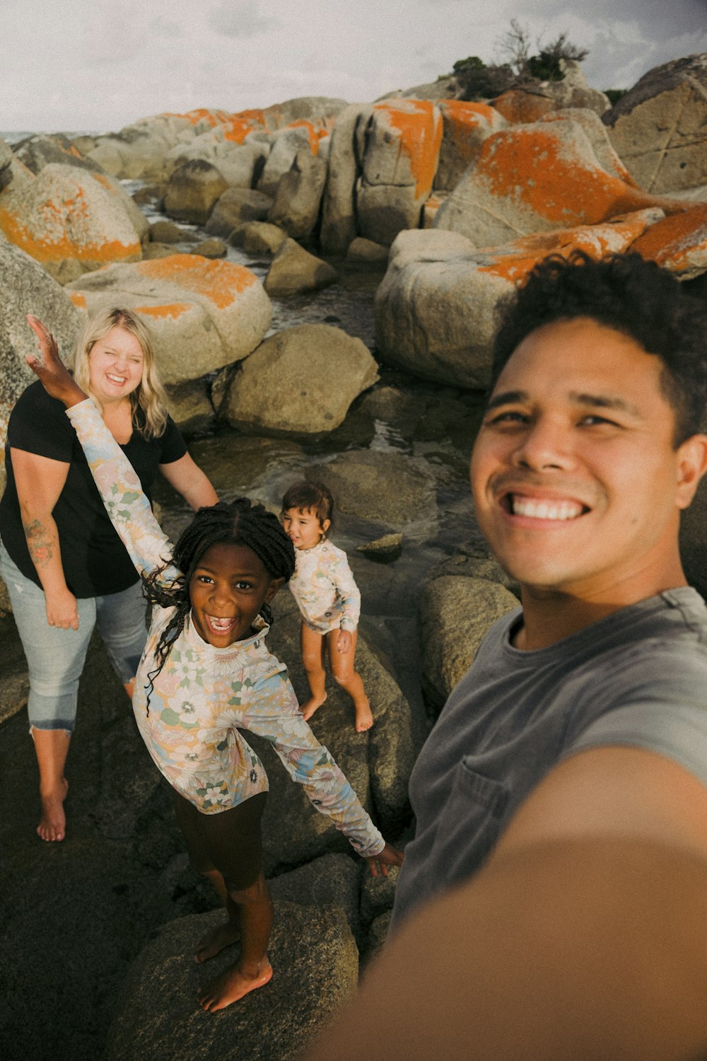 a group of people standing on top of a rocky beach