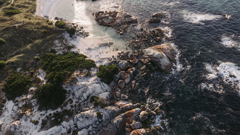 an aerial view of a rocky beach and ocean