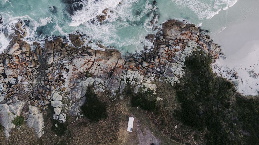 uma vista aérea de uma praia com rochas e água