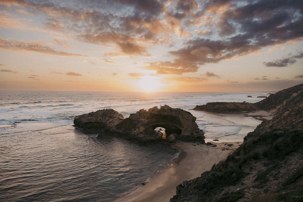 El sol se está poniendo sobre el océano y una playa