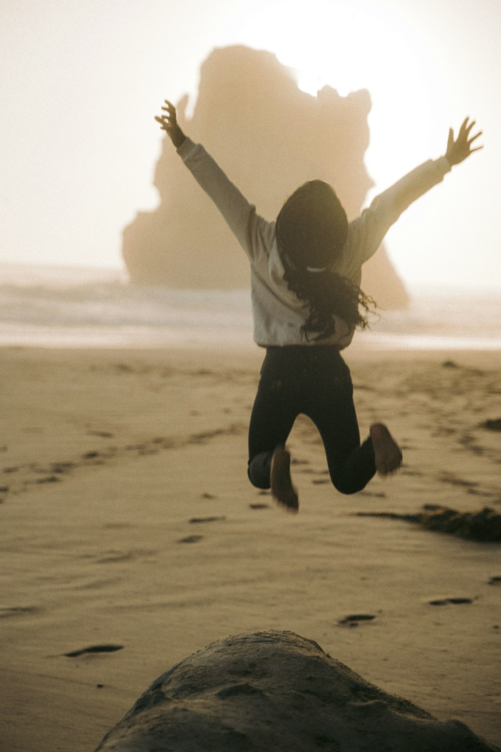 a person jumping in the air on a beach