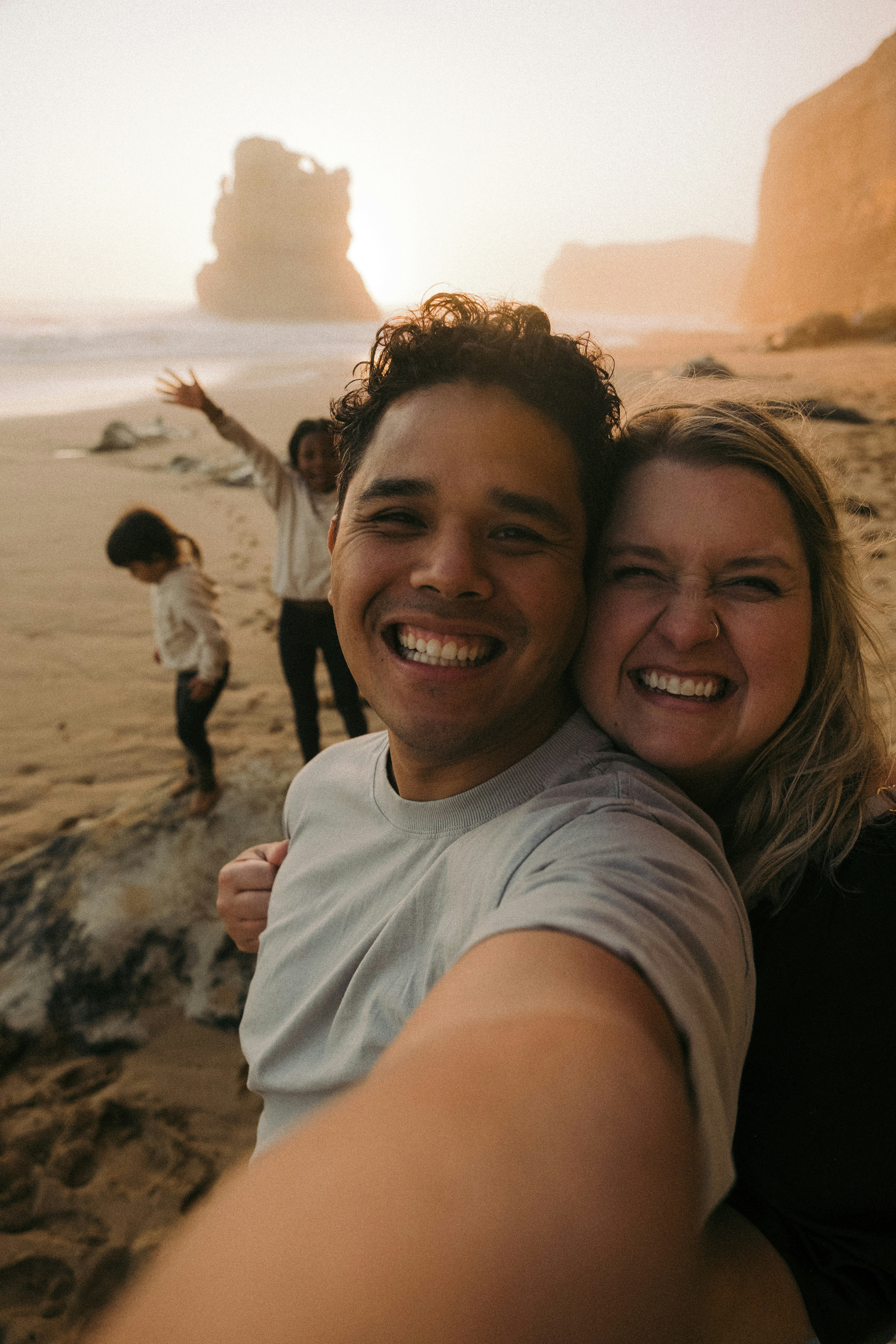 a man and woman taking a selfie on the beach