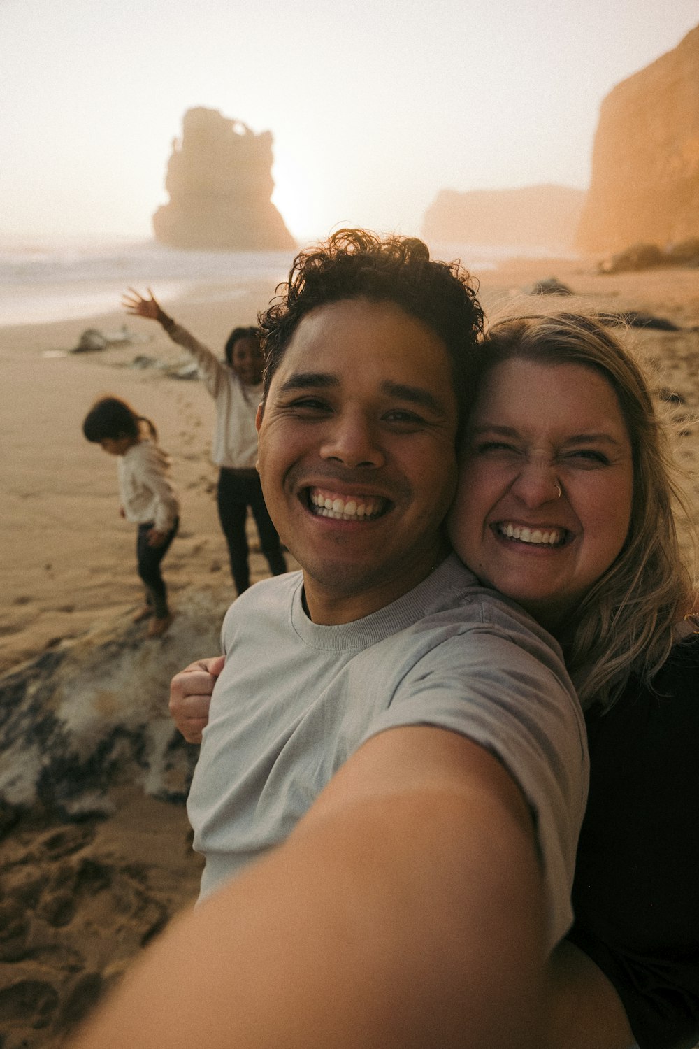 um homem e uma mulher tirando uma selfie na praia