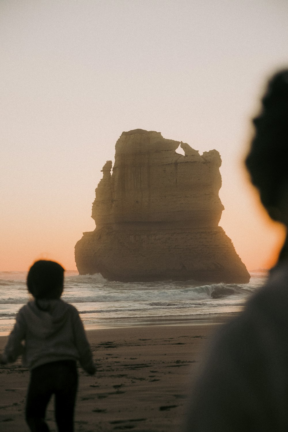 Un par de personas de pie en la cima de una playa