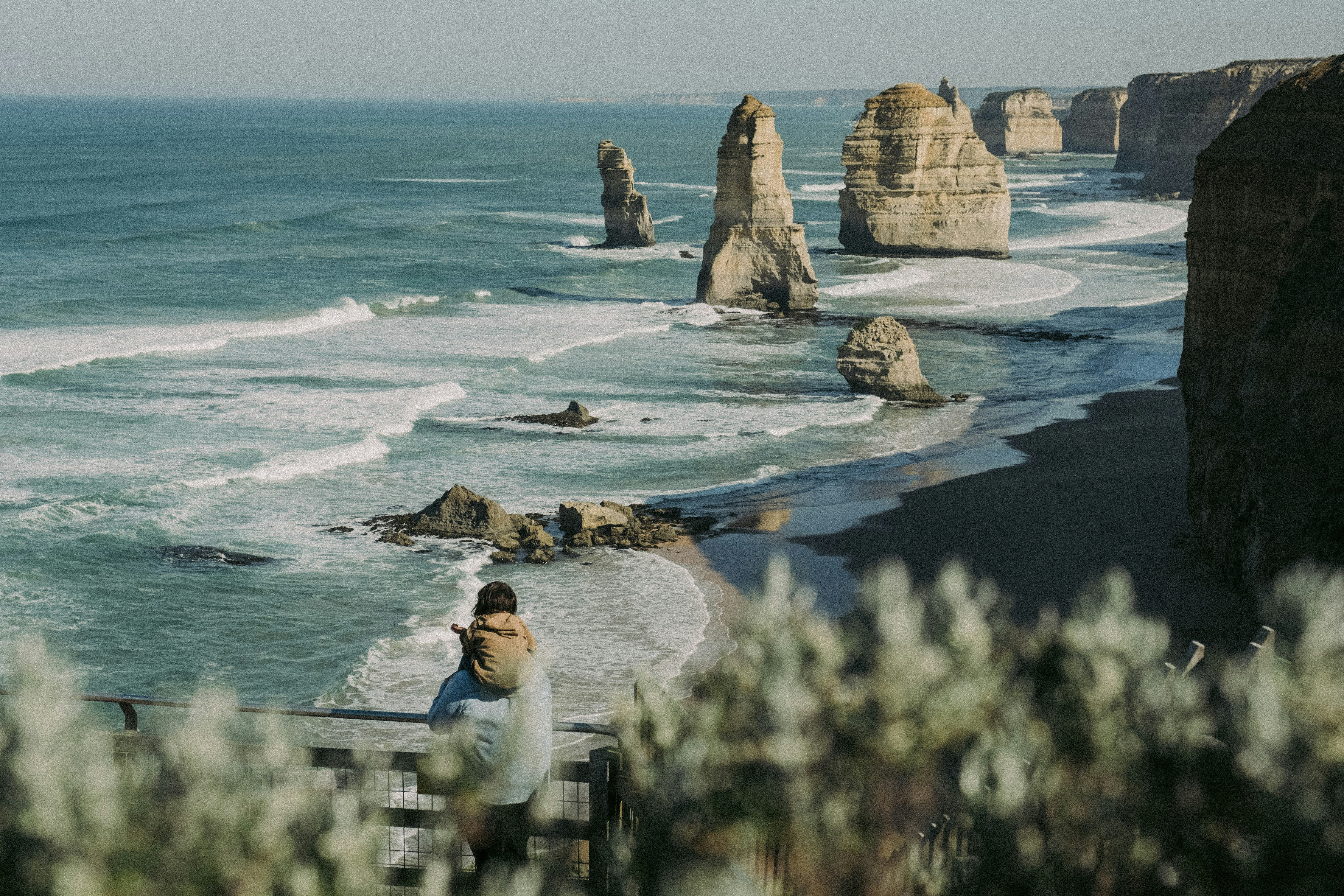 a person sitting on a bench near the ocean