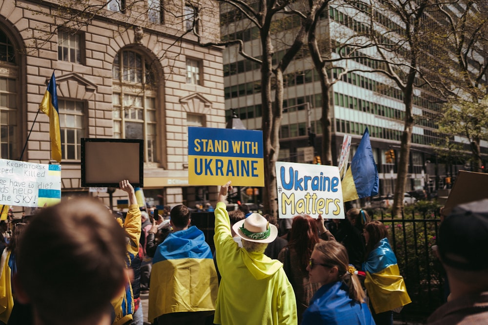 Un grupo de personas sosteniendo carteles frente a un edificio
