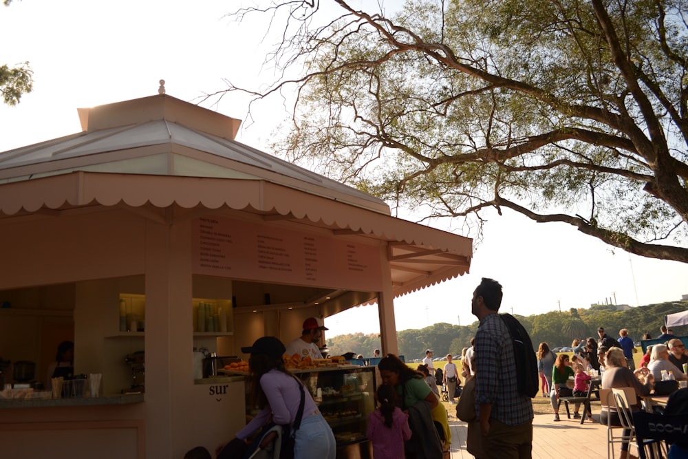 a group of people standing around a food stand