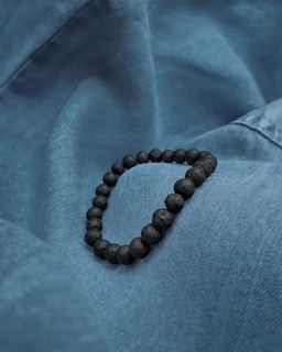 A stylish bracelet displayed on a soft fabric background.