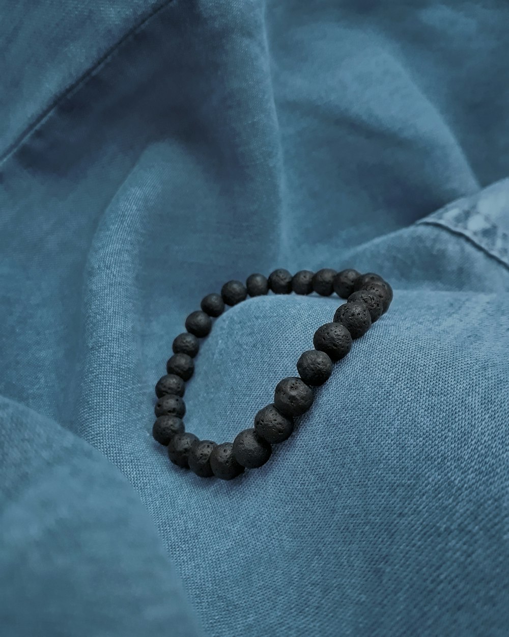 a wooden beaded bracelet with a letter v on it