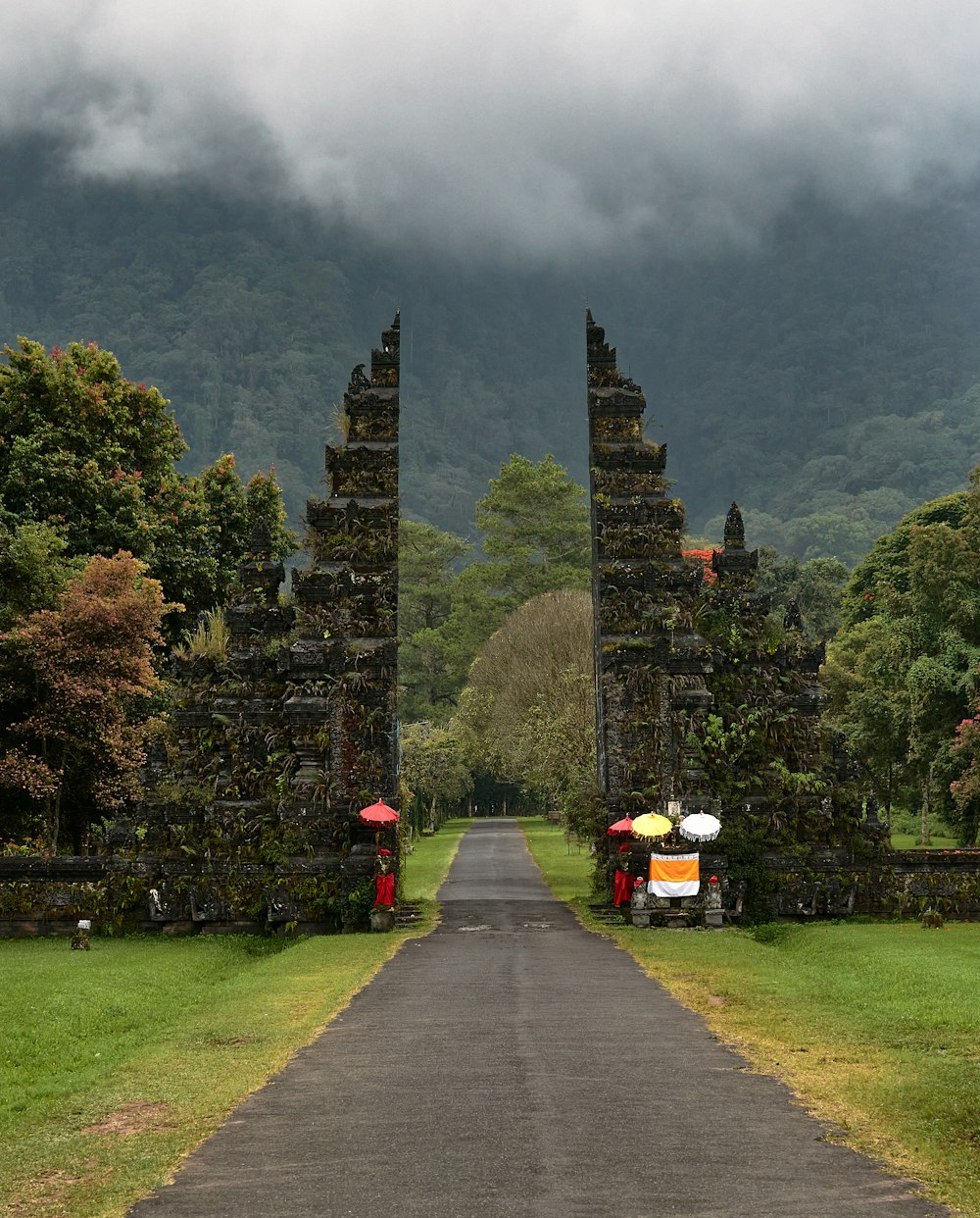 um par de pessoas com guarda-chuvas andando por uma estrada