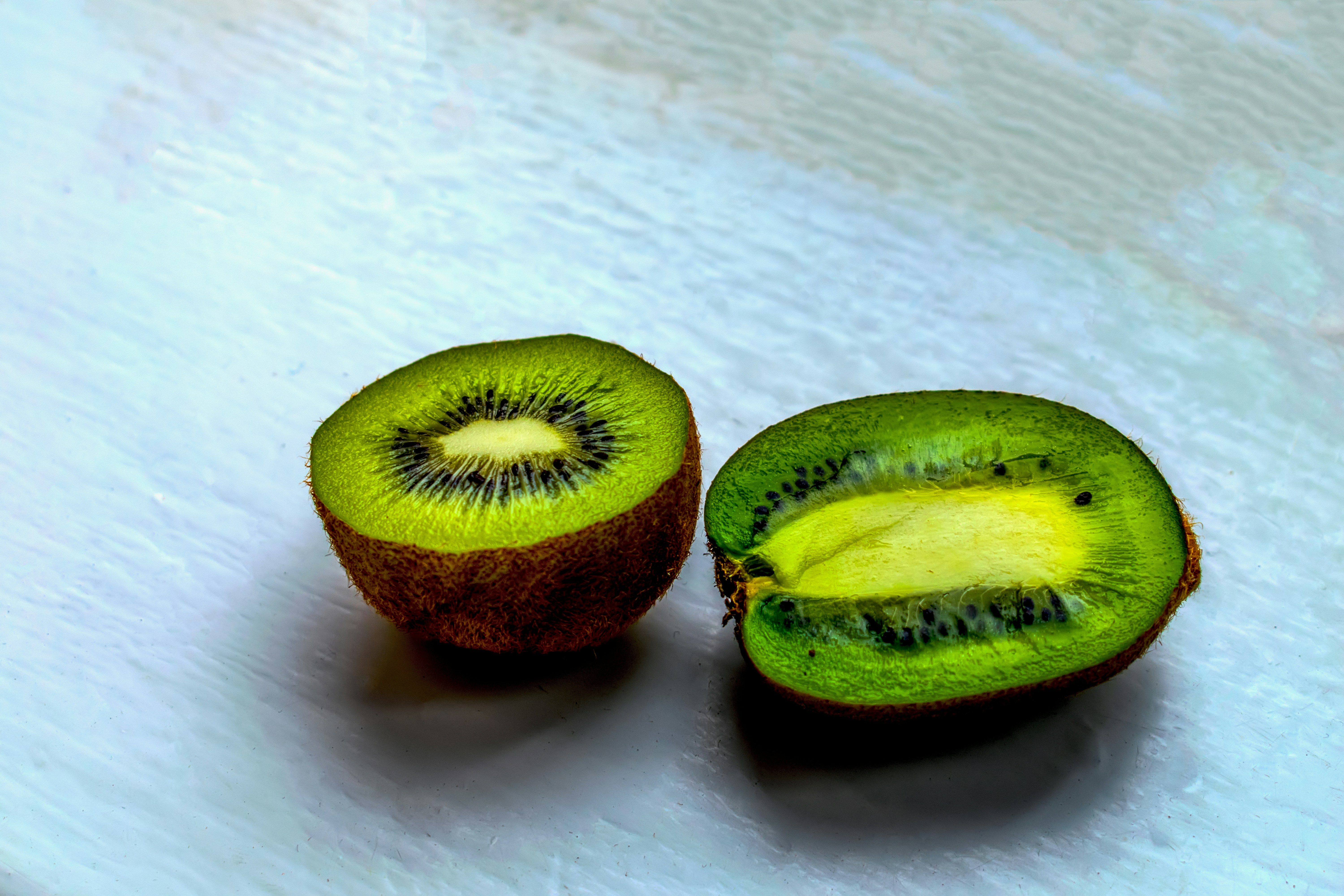 Kiwi dipotong menjadi dua pada permukaan putih