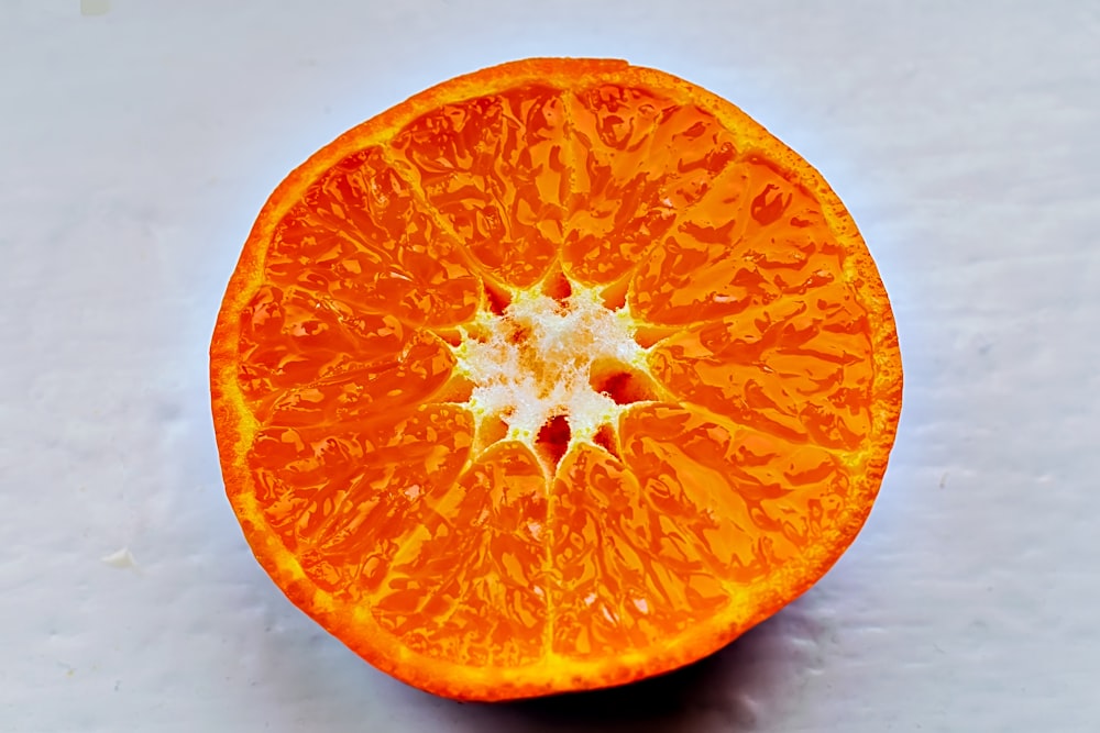 an orange cut in half on a white surface