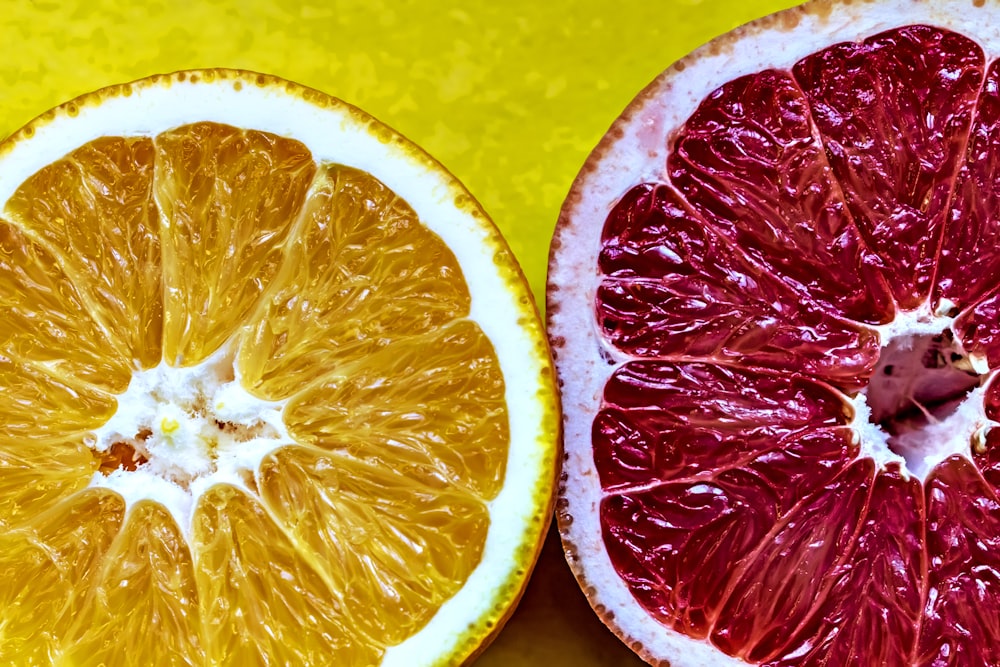 a grapefruit cut in half on a yellow background